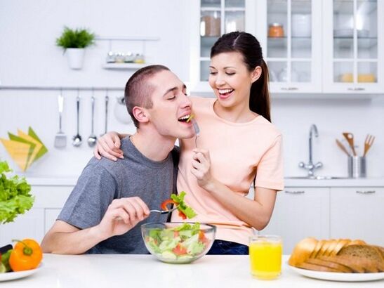 Момичето храни мъжа си с продукти за повишаване на потентността